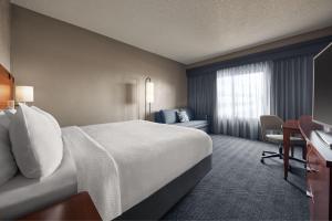 Courtyard by Marriott St. Louis Downtown West في سانت لويس: غرفة الفندق بسرير كبير ومكتب