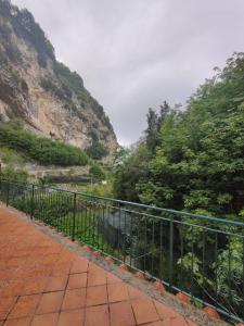 une clôture avec une vache devant une montagne dans l'établissement Casa Vacanze O'Mulin Ravello via fiume 2 incrocio Pontone, à Ravello