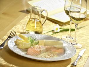 een bord eten op een tafel met wijnglazen bij Gasthof Restaurant Bürgerstüble in Sankt Peter