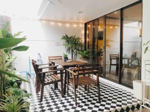 a dining room with a table and chairs on a checkered floor at Pannarai's House in Bangkok