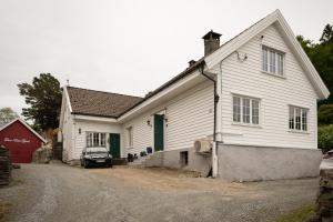 una casa blanca con un coche aparcado delante de ella en Historisk sjarm - moderne komfort 10min fra Bergen, en Bergen