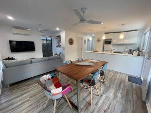 una cucina e un soggiorno con tavolo e sedie in legno di Seabreeze Villa on Mermaid Beach/ Broadbeach a Gold Coast