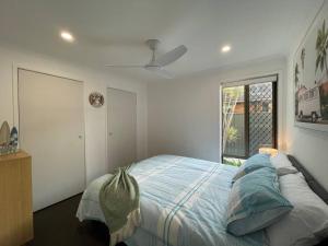 una camera da letto con un letto con lenzuola blu e una finestra di Seabreeze Villa on Mermaid Beach/ Broadbeach a Gold Coast