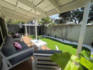 patio con divano e sedie sotto un pergolato di Seabreeze Villa on Mermaid Beach/ Broadbeach a Gold Coast