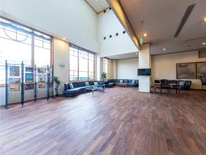 Großes Zimmer mit Sofas und einem Flachbild-TV. in der Unterkunft Hotel BELLMARE ホテルベルマーレ in Maizuru