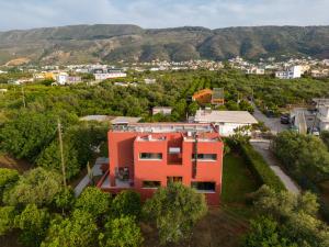 ein orangenes Haus mitten in einer Stadt in der Unterkunft Red Castle in Souda