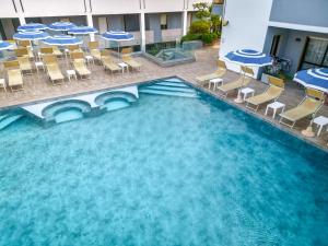 una vista sul soffitto di una piscina con sedie e tavoli di Residence Picalè ad Alghero