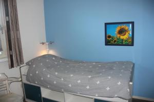 een bed in een kamer met een blauwe muur bij Amelander Paradijs 22 in Buren