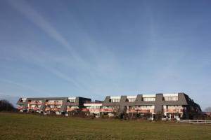 een groot gebouw met een veld ervoor bij Amelander Paradijs 22 in Buren