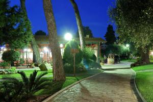 a walkway in a park with trees at night at Mediterranean Village San Antonio in Biograd na Moru