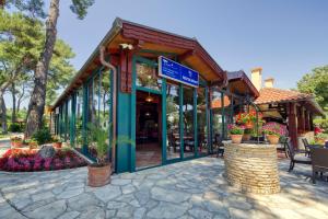 a restaurant with a blue sign on a building at Mediterranean Village San Antonio in Biograd na Moru