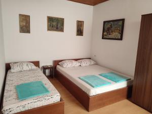 two beds in a small room with blue sheets at Apartment Mejdan in Mostar