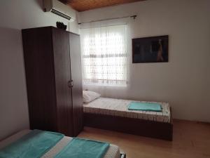 a room with two beds and a cabinet and a window at Apartment Mejdan in Mostar