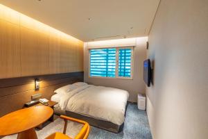 una camera con letto, tavolo e finestra di Incheon Airport Transit Hotel Terminal 1 a Incheon