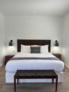 um quarto com uma grande cama branca e um banco em ViewPoint Hotel em York