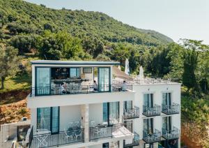 un edificio con balcones y una montaña en el fondo en SkyView apartments, en Herceg-Novi