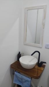 - un lavabo sur une table en bois avec un miroir dans l'établissement Aristobulo, à Buenos Aires