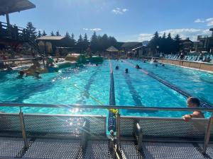 una gran piscina con gente en el agua en Apartment Family Besenova Aquapark - zlava 20p, en Bešeňová