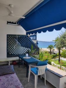 d'une terrasse avec une table et des chaises bleues donnant sur l'océan. dans l'établissement Brilliance Apartments, à Ouranoupoli