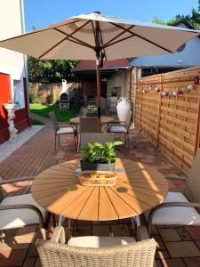 un tavolo in legno con ombrellone su un patio di Villa Lillybeth - Lake Balaton a Keszthely