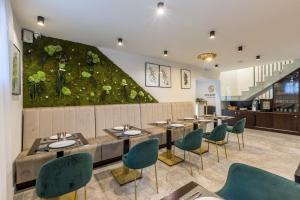 a restaurant with tables and chairs and an ivy covered wall at Sperone Hotel in Split