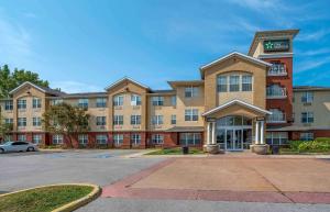 um edifício de apartamentos com um parque de estacionamento em frente em Extended Stay America Suites - Indianapolis - Northwest - I-465 em Indianápolis