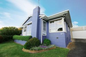 een blauw huis met een grasveld ervoor bij Bluey in Warrnambool