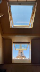 - une vue sur la tour Eiffel à travers une fenêtre dans l'établissement Cocoon Eiffel, à Paris