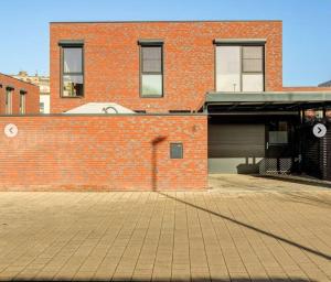 un bâtiment en briques avec un parking et un garage dans l'établissement Mooi vakantiehuis tussen Breda, Antwerpen, Gent & Hasselt, à Anvers