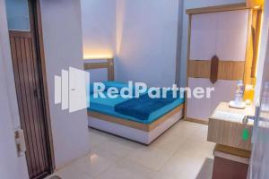 una piccola camera con letto blu di Hotel Rai's Palopo Exclusive Mitra RedDoorz a Palopo