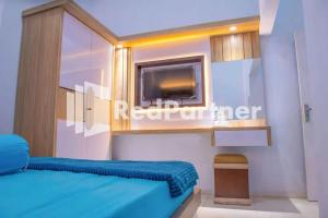 una camera con letto blu e TV di Hotel Rai's Palopo Exclusive Mitra RedDoorz a Palopo