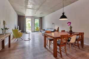 un soggiorno con tavolo e sedie in legno di havelblau Ferienlofts a Brandenburg an der Havel