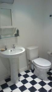 bagno con servizi igienici bianchi e lavandino di Millstone cottage a Oldham