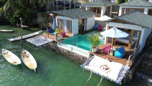 uma casa com piscina e um barco na água em Indigo Blue Ceningan em Nusa Lembongan