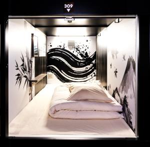 a bed in a room with a black and white wall at NINJA & GEISHA in Osaka