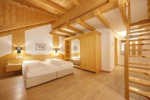 1 dormitorio con 1 cama en una habitación con techos de madera en Hotel Goldene Rose, en Brunico