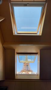 - une vue sur la tour Eiffel à travers une fenêtre dans l'établissement Cocoon Eiffel, à Paris