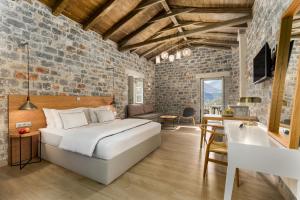 a bedroom with a large bed in a brick wall at Trapela Limeni Luxury Suites in Limeni