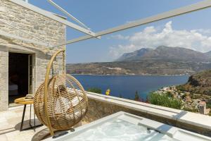 a room with a tub and a view of the water at Trapela Limeni Luxury Suites in Limeni