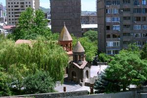 una piccola chiesa con due torri in una città di Royal Plaza by Stellar Hotels, Yerevan a Yerevan