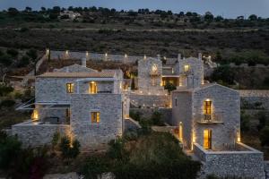 an aerial view of a stone house with lights at Trapela Limeni Luxury Suites in Limeni