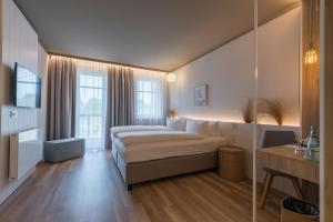 1 dormitorio con 1 cama y 1 sofá en una habitación en Hafenhotel zu Putbus, en Putbus