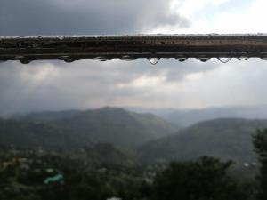 a view from a window with water droplets on it at Navid's Holiday Resort and Hotel, Murree in Ghora Gali