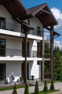 Un grand bâtiment blanc avec balcon est disponible. dans l'établissement Chillax, à Bukovel