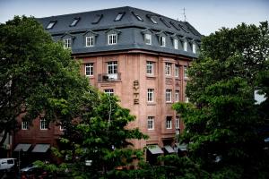 ein großes Backsteingebäude mit schwarzem Dach in der Unterkunft Syte Boutique Hotel Mannheim in Mannheim