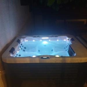 a jacuzzi tub with a light in a bathroom at Maison familiale avec jacuzzi et piscine in La Rochelle