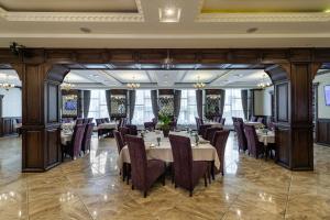 een restaurant met tafels en stoelen in een kamer bij Avalon Palace in Ternopilʼ