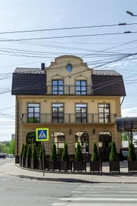 een groot geel gebouw met een balkon erboven bij Avalon Palace in Ternopilʼ