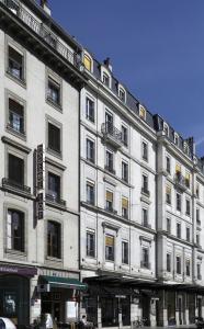 um grande edifício branco na esquina de uma rua em Hotel Tor em Genebra