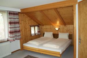 una camera da letto con letto in una camera in legno di Hotel Pension Spycher a Kandersteg